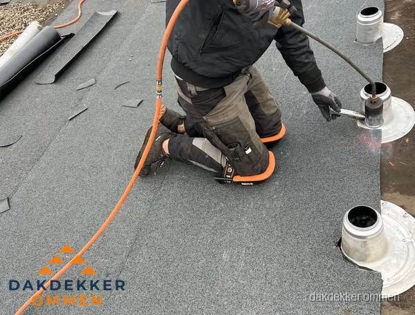 Dakdekker repareert bitumen dakleer bij dakdoorvoer in Ommen Dakdekker repareert bitumen dakleer bij dakdoorvoer in Ommen