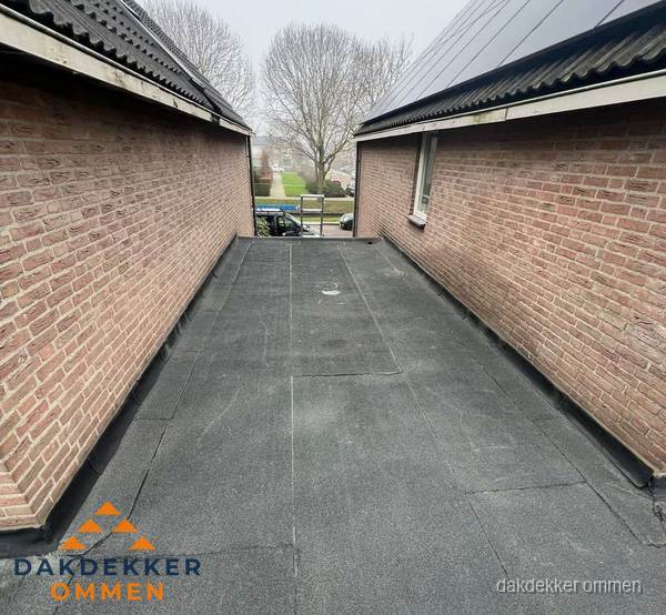 Plat dak met bitumen dakbedekking tussen bakstenen muren in Ommen Plat dak met bitumen dakbedekking tussen bakstenen muren in Ommen