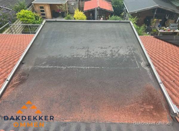 Verouderd plat dak met slijtage tussen schuine daken in Ommen Verouderd plat dak met slijtage tussen schuine daken in Ommen