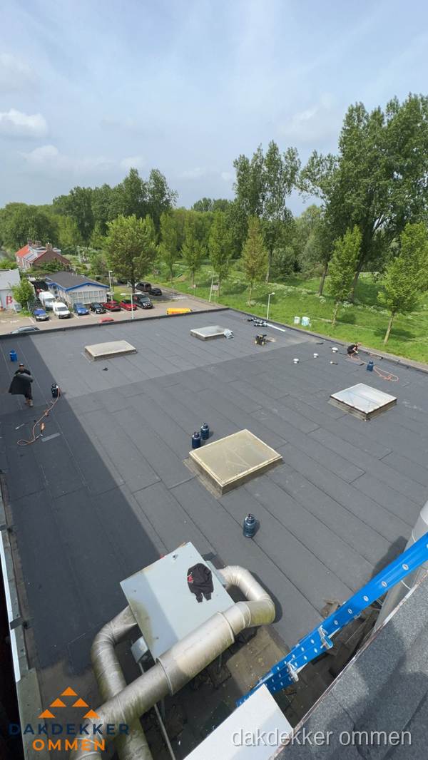 Dakdekker aan het werk op groot plat dak met bitumen in Ommen Dakdekker aan het werk op groot plat dak met bitumen in Ommen