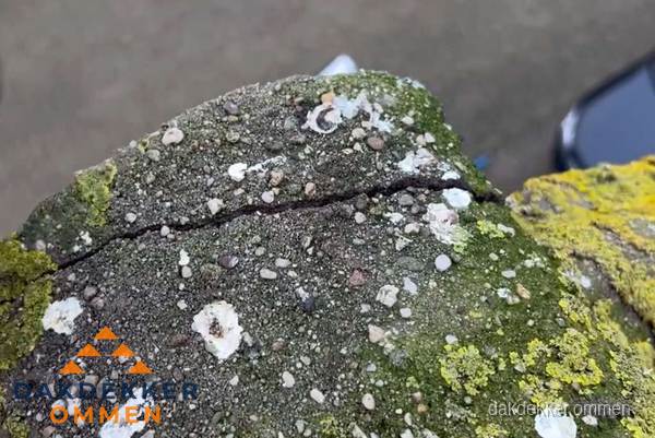 Beschadigde en verweerde nokvorst met scheuren en mos in Ommen Beschadigde en verweerde nokvorst met scheuren en mos in Ommen