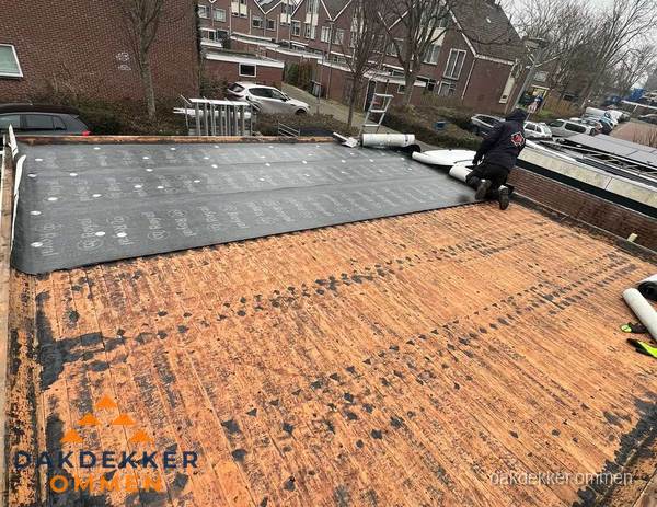 Dakdekker legt onderlaag op plat dak met houten constructie in Ommen Dakdekker legt onderlaag op plat dak met houten constructie in Ommen
