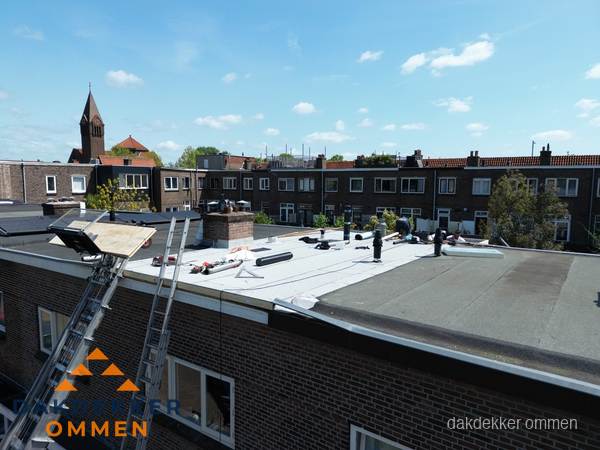 Dakdekkers aan het werk op plat dak in Ommen