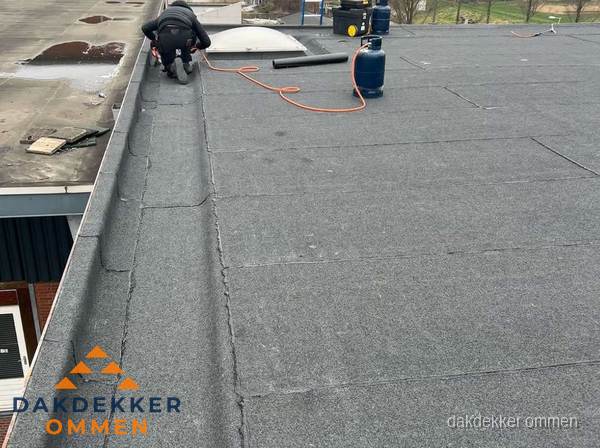 Dakdekker repareert bitumen dakbedekking op groot plat dak in Ommen Dakdekker repareert bitumen dakbedekking op groot plat dak in Ommen